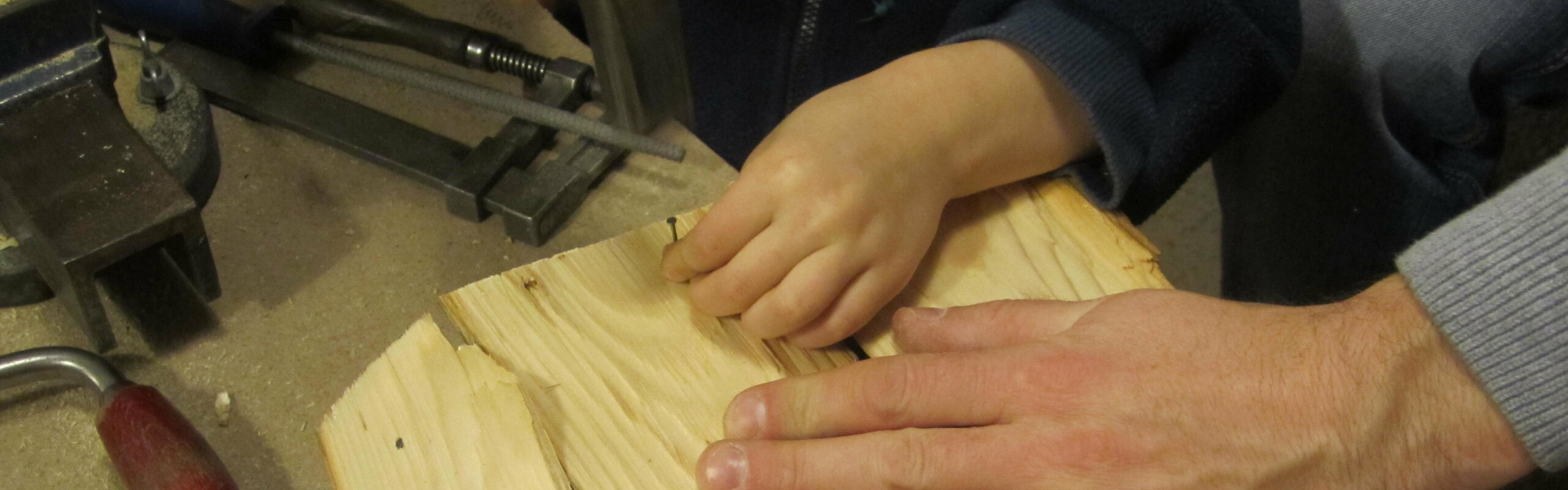 Erwachsene Hand hilft Kinder-Hand beim Werken